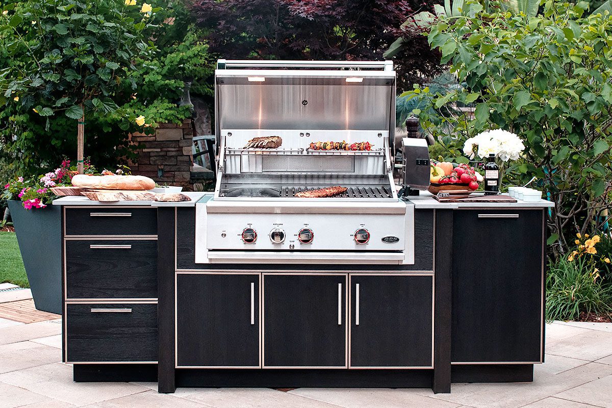 11An outdoor kitchen set with the barbecue turned on, grilling ribs and skewers