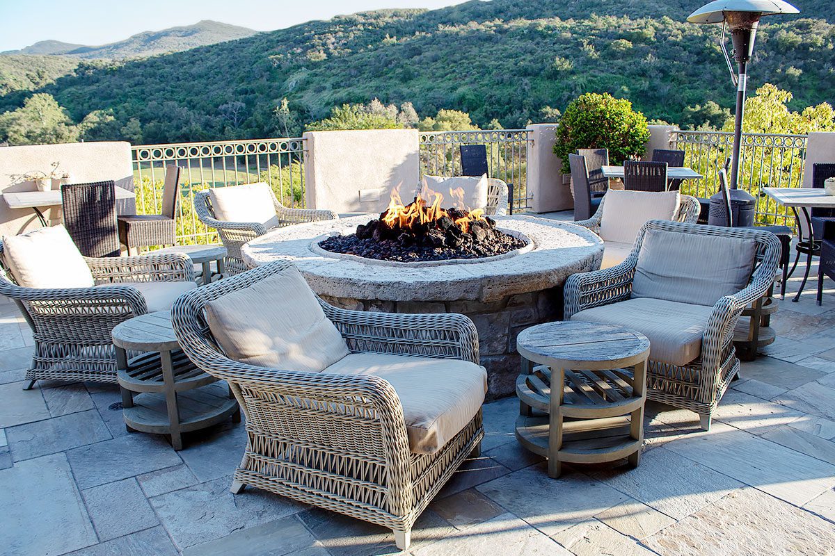 11A beautiful stone fire pit on the patio with lounge chairs around it